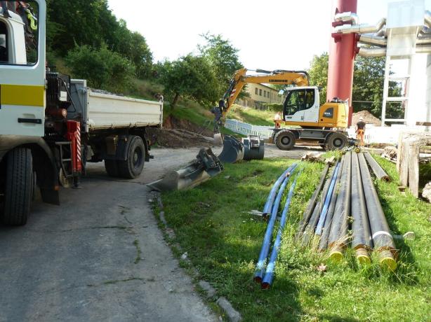 Baustellenlogistik mit Mobilbagger und Transportfahrzeug